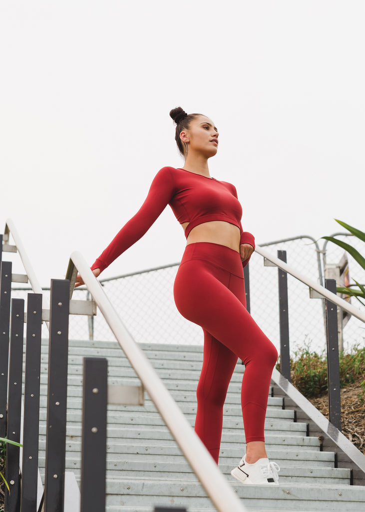 Activewear women's red workout top, full length legging, image of model on stairs