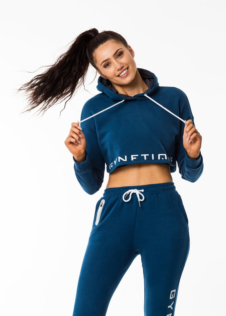 Gynetique gym clothes nz, women's cropped hoodie in blue colour, lined hood, white drawstring, half print logo design 